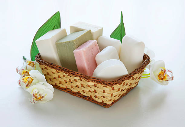 a basket full of soap bars with different shapes and colors and some flowers