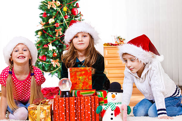 istock Kids sit beside Christmas presents 153476326