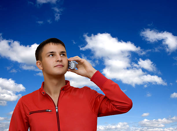 Attractive young man holding out cellphone. stock photo