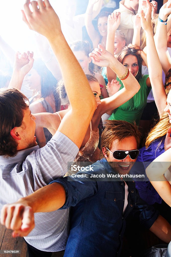 Groupe de jeunes gens danser dans une discothèque - Photo de Groupe multi-ethnique libre de droits