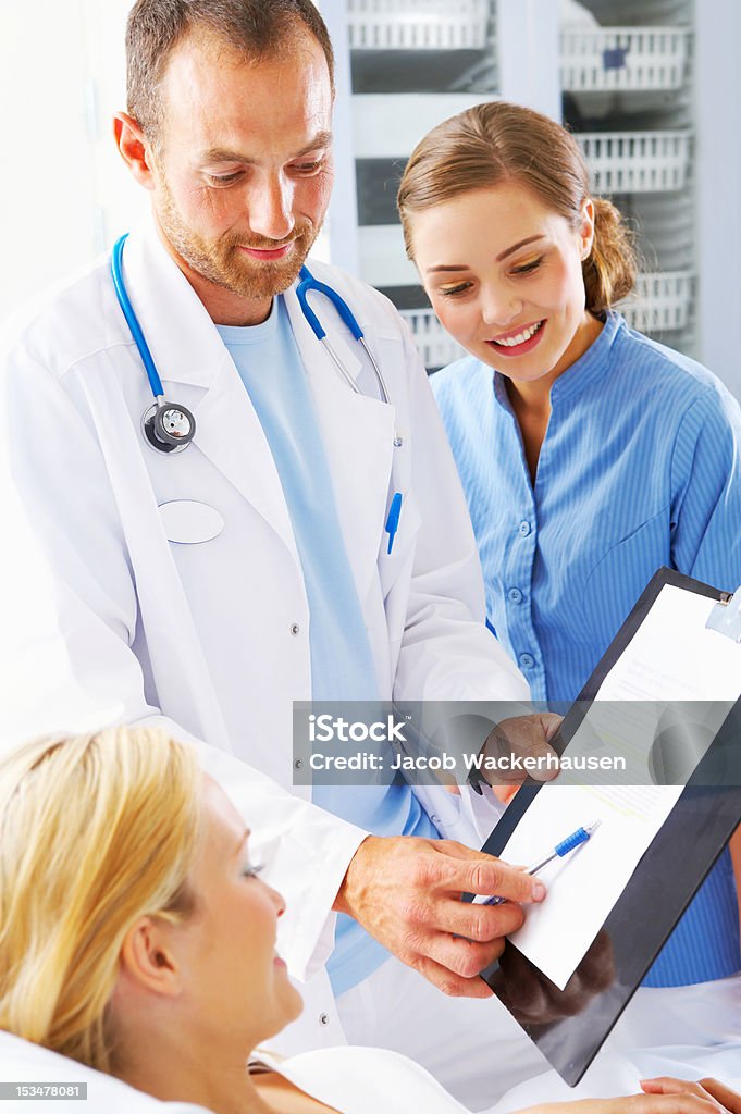 Maschio medico mostrando la relazione medica per il paziente - Foto stock royalty-free di Paziente