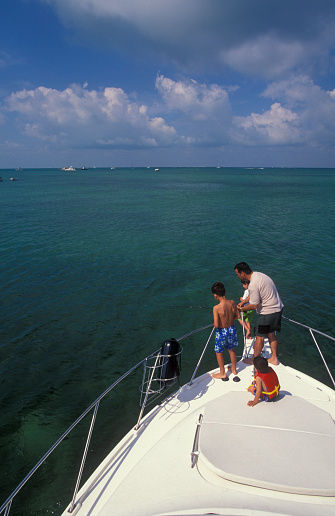Father with sons fishing on the boat's bow, Florida Keys, USA