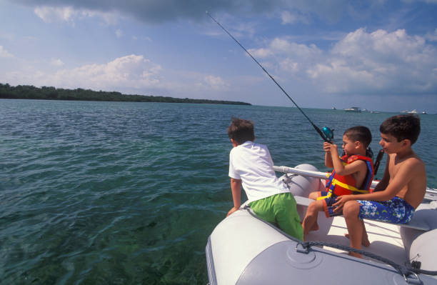 Happy father and his little son fishing together outdoors