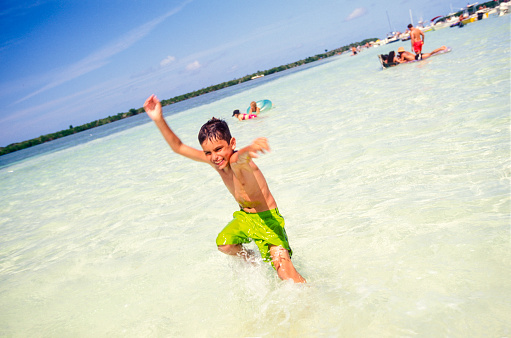 Young boy enjoying the crystal waters on the beach, Florida Keys, USA