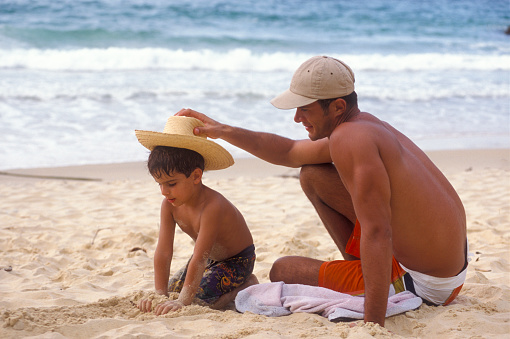 Father and son playing on a sandy beach, Venezuela