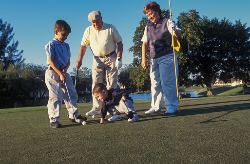 Grandparents playing golf with two grandsons, Miami, Florida, USA
