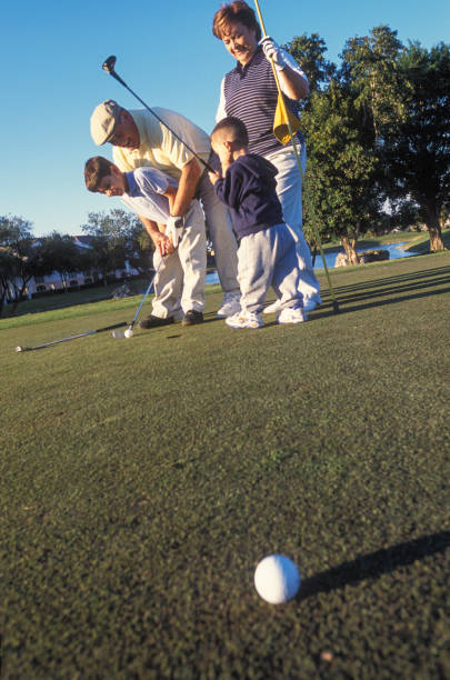 Grandparents playing golf with two grandsons, Miami, Florida, USA