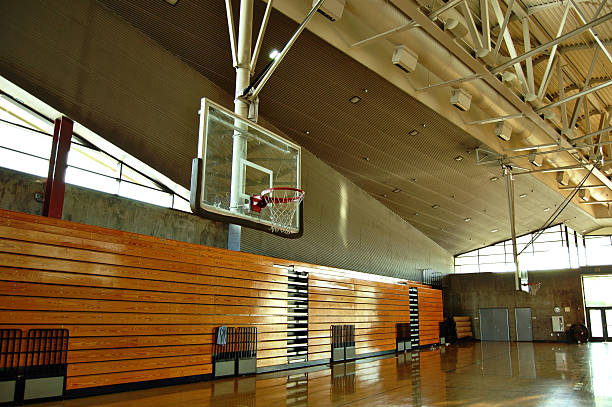 High school gym Empty high school gym with basketball hoop and bleachers school bleachers stock pictures, royalty-free photos & images