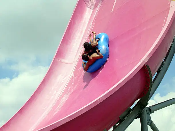Couple enjoying a fun ride on a waterpark slide.