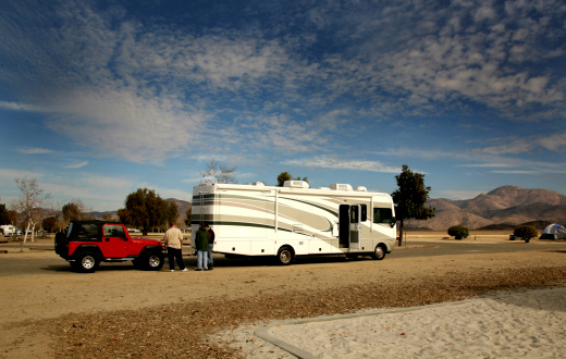 RV Coach Towing an Offroad 4X4 Red Vehicle