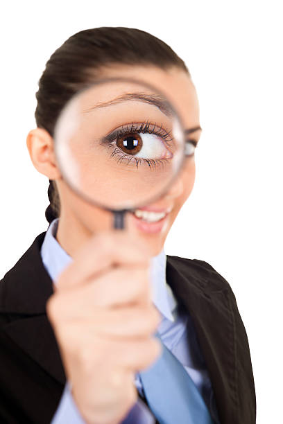 istock woman looks through magnifying glass 153480553