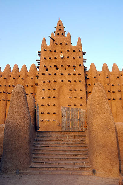 Front gate and minaret on Djenne mosque Vertical view of the front entrance and gate with a minaret on Djenne's mud mosque in Mali mali stock pictures, royalty-free photos & images