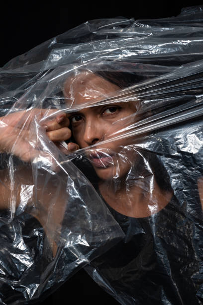 istock A woman with a plastic bag over her head looking through a hole. Protest against the use of plastic in the world. Environmental problems. 1534809129