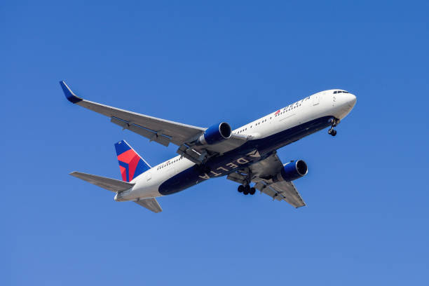 United States air company Delta Airlines with aircraft Boeing 767-332 approaching to land at Lisbon International Airport against blue sky stock photo