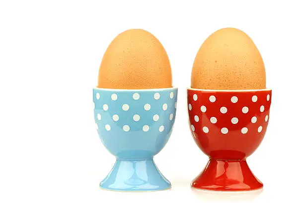 Photo of colorful and decorated egg cups with eggs