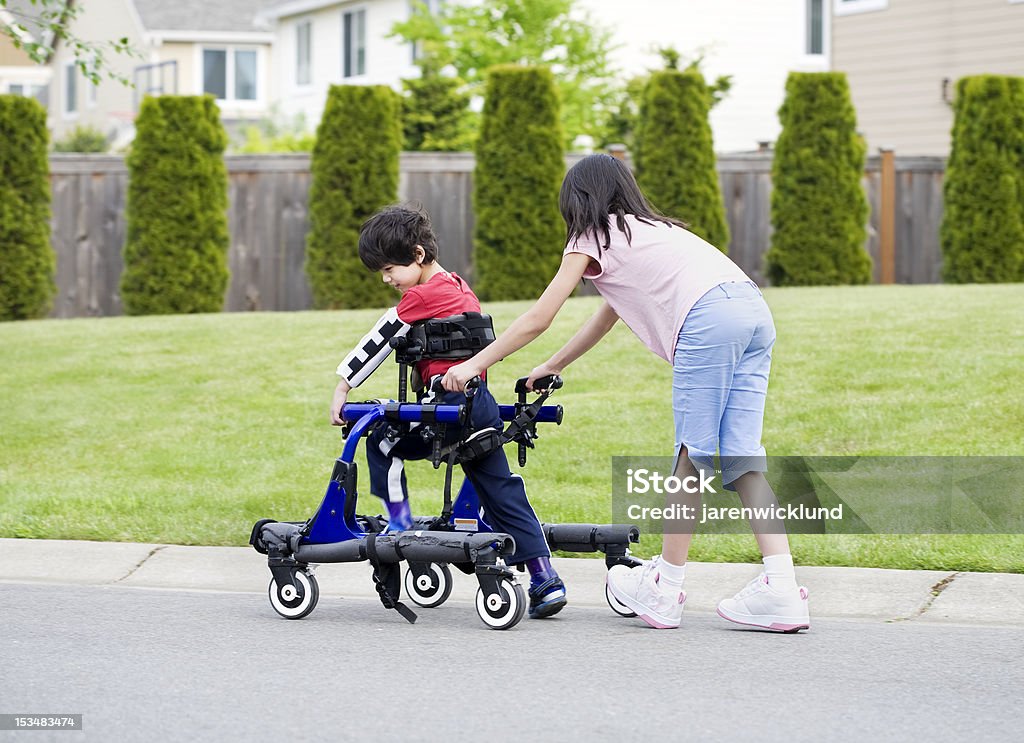 Irmã mais nova irmão ajudando deficiência em walker - Royalty-free Criança Foto de stock