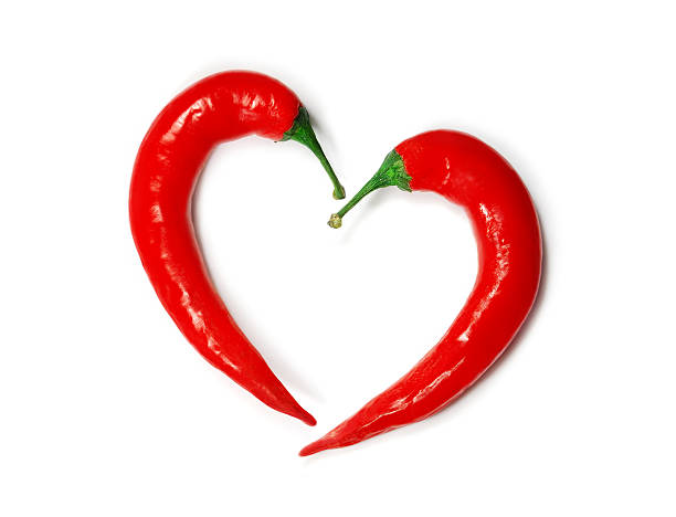 два chilli перец образуя форму сердца - chili pepper стоковые фото и изображения