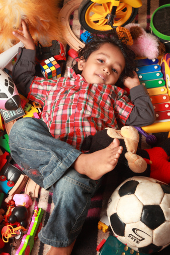 A little boy laying on floor with his toys