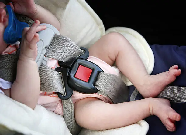 Baby in car-seat bucked up.