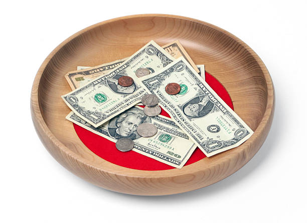 Wooden offering plate containing bills and coins