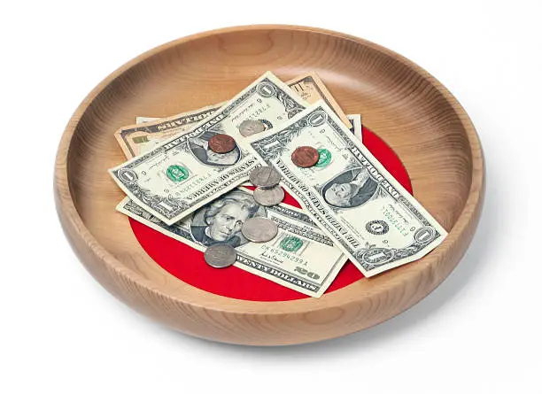 Wooden offering plate with paper bills and coins