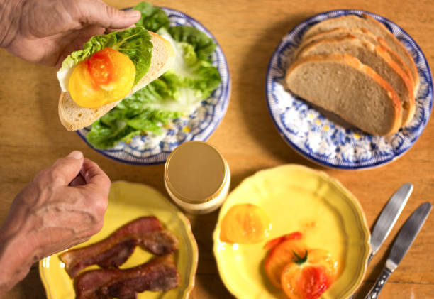 istock Man Making BLT Sandwich with Heirloom Tomato 1534883373