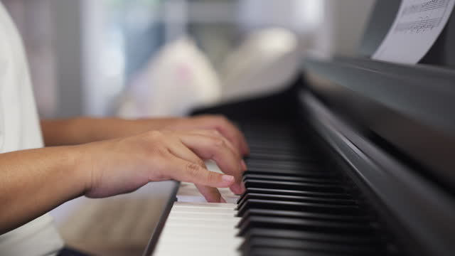 Close-up of a woman hands practicing piano playing a music
