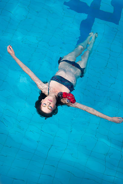 istock Woman with bikini floating in pool 153490616