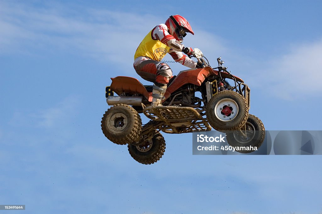 An impressive quadbike jump on mid-air caught from below Quad bike jumping high Quadbike Stock Photo