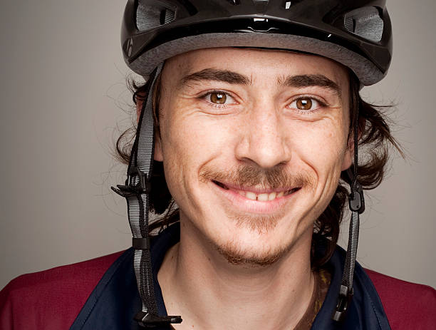 Young Man Smiling and wearing Bycicle Helmet Protection stock photo