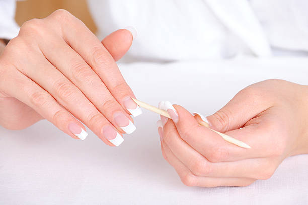 istock Female removing cuticle from fingers 153492627