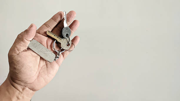 istock A man's hand is holding two keys and a keychain 1534940782