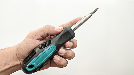 A man's hand is holding a screwdriver on a white background.