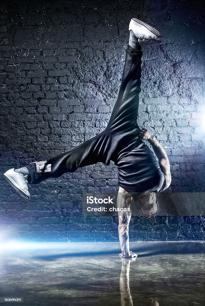 Young strong man break dance Young strong man break dance. On dark wall background. 20-29 Years Stock Photo