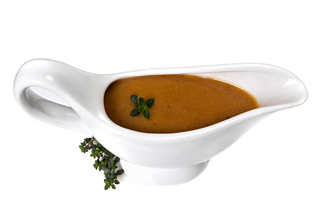 Gravy Thyme gravy in white gravy boat, isolated.  Delicious! gravy stock pictures, royalty-free photos & images