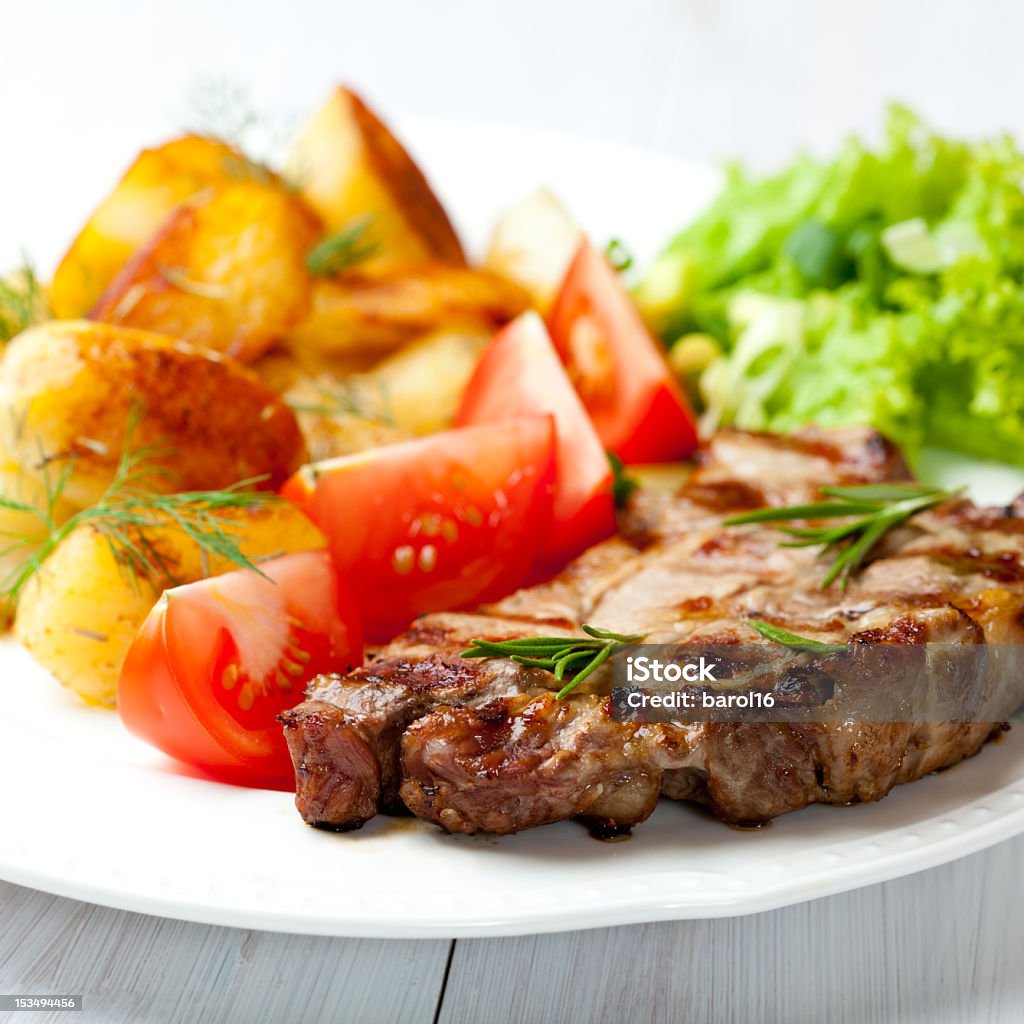 Bistecca alla griglia con patate arrosto e verdure fresche - Foto stock royalty-free di Alla griglia