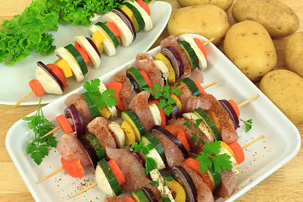 Grill skewer shashliks preparation - delicious meat cuisine with zucchini, onions, carrots and peppers
