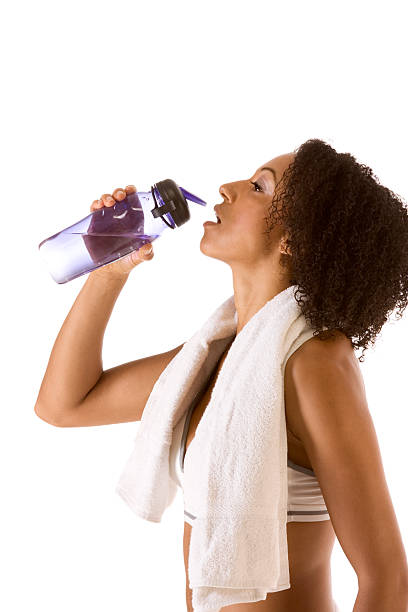 Sporty woman with bottle of water and towel stock photo