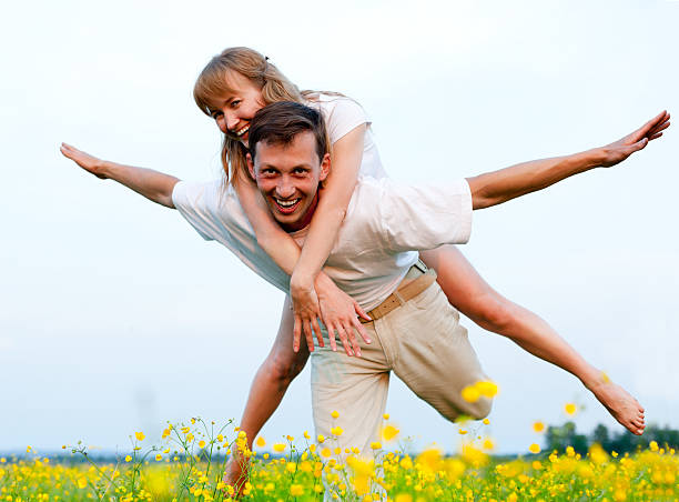 istock young beautiful couple plays and hugs in grass field 153497257