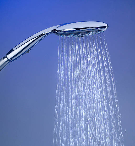 Large silver shower head in use stock photo