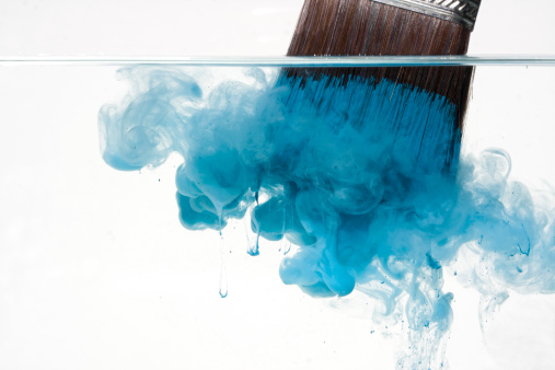 viewing a loaded paintbrush being submerged into water with the paint beginning to disperse