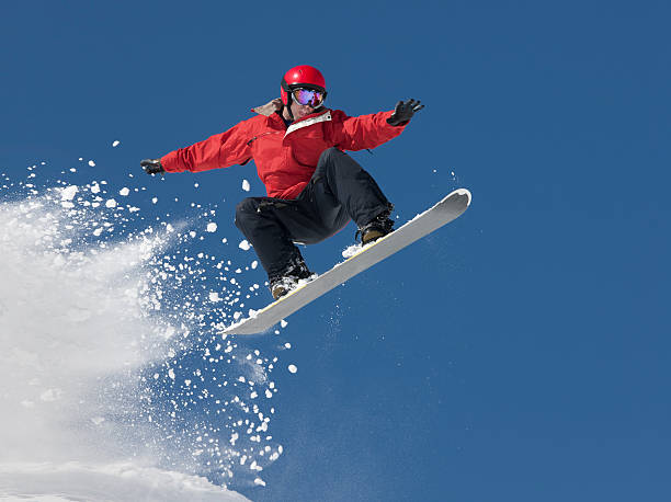 Snowboard Jump Young man in mid-air making snowboard jump. snowboarding stock pictures, royalty-free photos & images