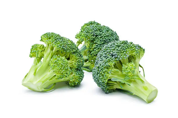 Arrangement of three fresh ripe raw broccoli pieces closeup isolated on white background