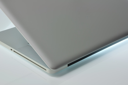 Laptop on a glossy surface illumination. Side View.