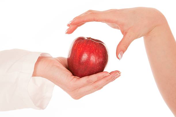 Mão agarrando apple a partir de outro - fotografia de stock