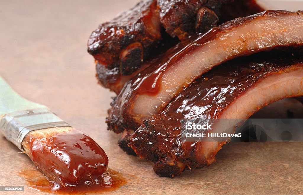 BBQ Ribs Delicious BBQ babyback ribs with tangy sauce and a sauce brush Barbecue - Meal Stock Photo