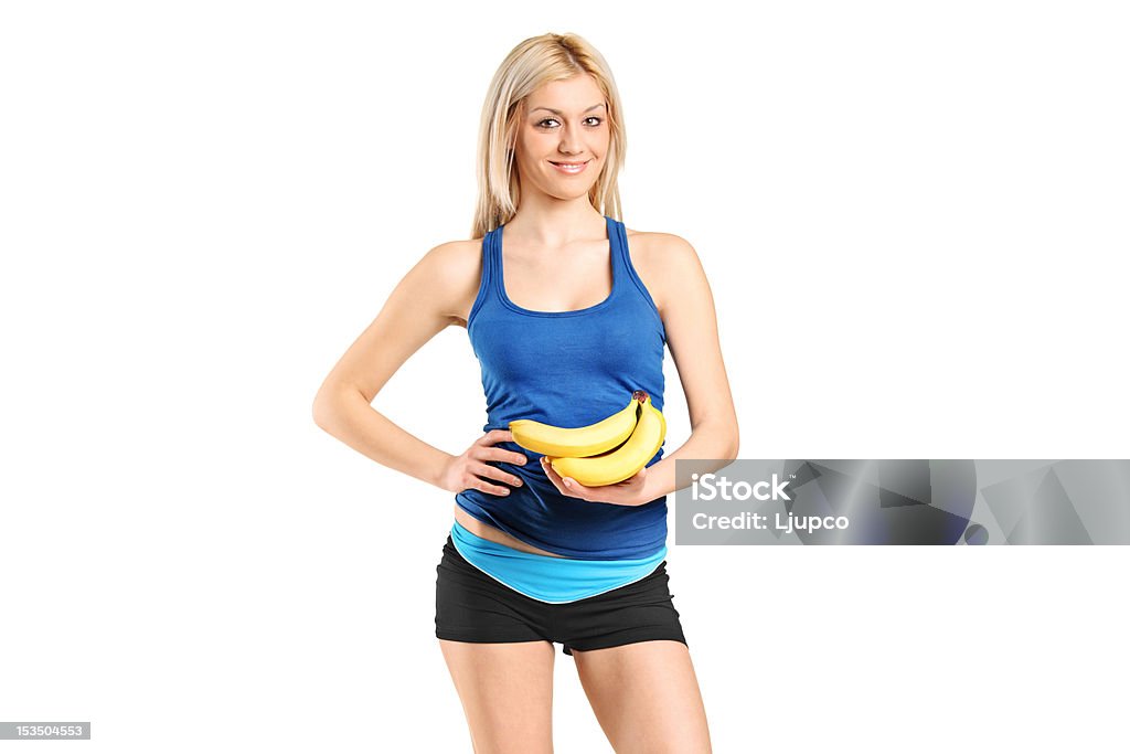Portrait of a female athlete holding bananas Portrait of a female athlete holding bananas isolated on white background Adult Stock Photo