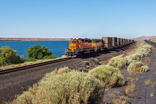 Kennewick, WA, USA - July 1st, 2023: Moving locomotive in the desert area near the highway