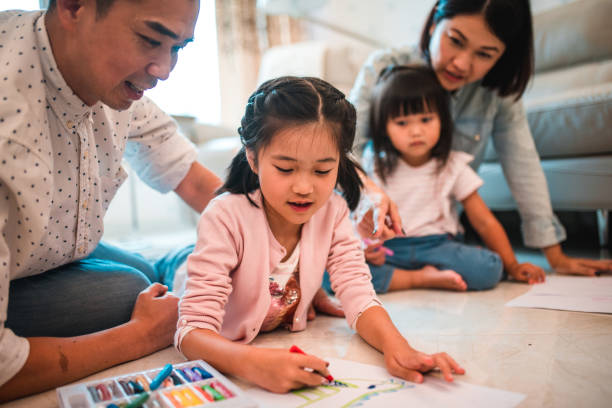 istock Creative Asian Sisters Painting With Crayons At Home 1535060061