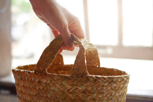 Woman holding a basket made of pandan leaves. Rural women use pandan leaves to make handicrafts to create value for local materials.